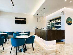 a restaurant with blue chairs and tables and a bar at Hotel Perla Dello Ionio in Torre Lapillo