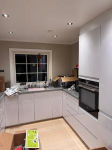 a large kitchen with white cabinets and a window at 柠檬树 in Gystad