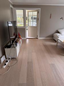 an empty living room with a hard wood floor at 柠檬树 in Gystad +1 photo