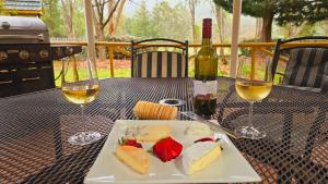 a plate of food and two glasses of wine on a table at Chalets Lumineux in Bright