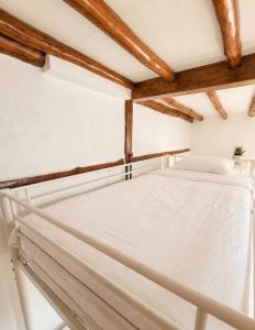 ein weißes Bett in einem Zimmer mit Holzbalken in der Unterkunft yangwon lavender 양원라벤더 금강송숲길 협곡열차 in Wŏn'gok