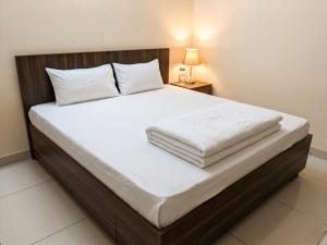 a bed with white sheets and pillows in a room at Hotel Aarav Grand Chandigarh in Chandīgarh