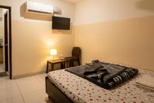 a bedroom with a bed and a tv on the wall at Hotel Aarav Grand Chandigarh in Chandīgarh