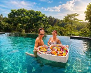 two women in a swimming pool with a basket of food at D'Nanda mini hotel Ubud in Ubud