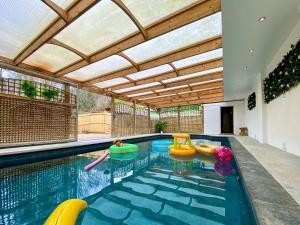 an indoor swimming pool with chairs and a swimming pool at Pine Lodge - Uk46279 in Camerton +20 photos