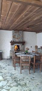 a stone fireplace in a room with benches and a table at Капсъзовата къща in Leshten