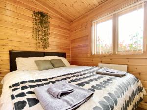 a bedroom with a bed in a wooden cabin at Pine Lodge - Uk46279 in Camerton