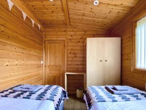 a bedroom with two beds in a wooden cabin at Pine Lodge - Uk46279 in Camerton