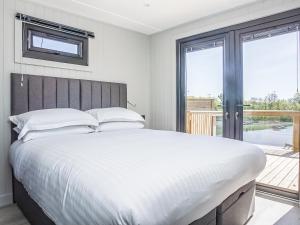 a bedroom with a large bed and a large window at Hummingbird Lodge - Uk51940 in Yarm