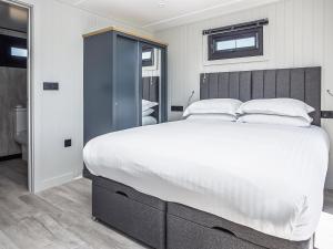 a bedroom with a large bed with white sheets and pillows at Hummingbird Lodge - Uk51940 in Yarm +9 photos