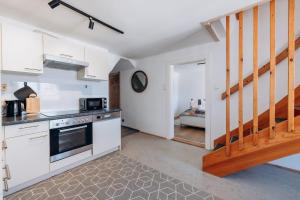 a kitchen with white appliances and a staircase at KUL App 5 by Alpenidyll Apartments in Öblarn