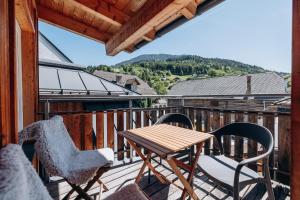a deck with a table and chairs on a balcony at KUL App 6 by Alpenidyll Apartments in Öblarn