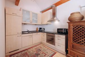 a kitchen with white cabinets and a microwave at KUL App 6 by Alpenidyll Apartments in Öblarn