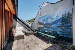 a mural on the side of a building with a bench at KUL App 5 by Alpenidyll Apartments in Öblarn +10 photos
