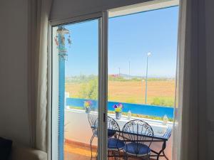 a view of a balcony with a table and chairs at Apartment inside a apartment complex by the beach with public pool in Marina Smir