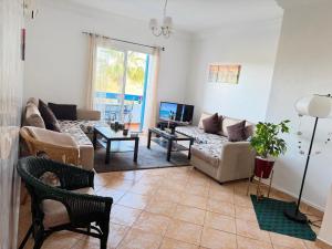 a living room with a couch and a table at Apartment inside a apartment complex by the beach with public pool in Marina Smir
