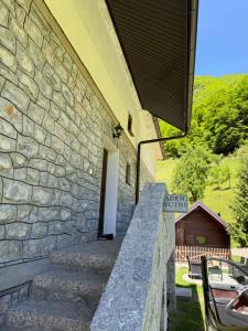 a stone building with stairs leading up to a door at Guest House Vuthaj in Vusanje