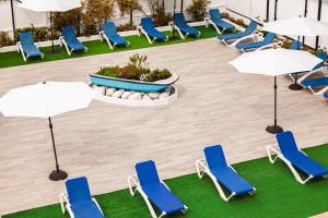 a group of chairs and umbrellas in a pool at Apartamentos Quintasol in Malgrat de Mar