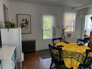 a dining room with a yellow table and chairs at Le Petit Saint-Joseph in Saint-Alexis-des-Monts