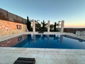 a swimming pool in front of a house at carmel cabins suite 6 in Yājur