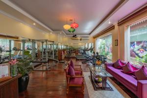a room with purple couches and tables and windows at Hotel Somadevi Angkor Resort & Spa in Siem Reap