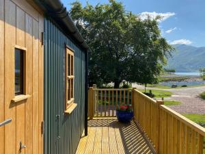 a house with a deck with a flower pot on it at Corran Shepherds Hut in Corran +8 photos