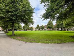 a large green field with trees in front of a building at The Necessarium in Canterbury