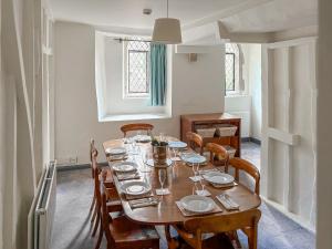 a dining room with a table with plates and glasses on it at The Necessarium in Canterbury