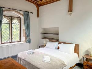 a bedroom with a bed with white sheets and a window at The Necessarium in Canterbury