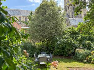 a table and chairs in a garden in front of a cathedral at The Necessarium in Canterbury