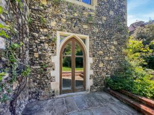 an entrance to a stone building with a glass door at The Necessarium in Canterbury +16 photos