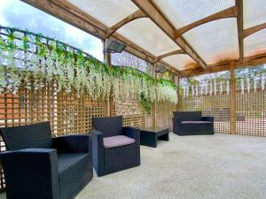 a pergola with chairs and plants on a patio at Apple-Uk46285 in Camerton