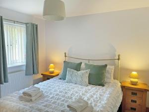 a bedroom with a bed with towels on it at Bwthyn Bwlch in Denbigh