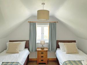 two twin beds in a room with a window at Bwthyn Bwlch in Denbigh