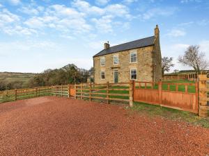 an old house with a fence in front of it at Binchester Crag Farm in Bishop Auckland