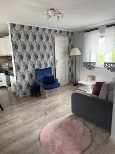a living room with a couch and a blue chair at Dom nad jeziorem in Lubkowo