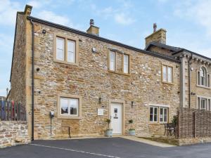 an old brick house with white windows at Cross Keys Cottage in Skipton