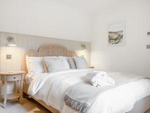 a bedroom with a large bed with white sheets and pillows at Cross Keys Cottage in Skipton