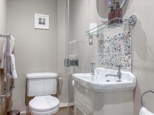 a white bathroom with a toilet and a sink at Cross Keys Cottage in Skipton