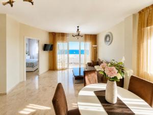 a living room with a table with a vase of flowers at Algaida, beach apartment in Mijas Costa