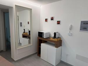 a room with a mirror and a microwave on a counter at Bellavista-Verceia in Verceia