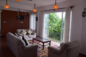 a living room with two couches and a table at Sentinels Hotel Kandy in Kandy