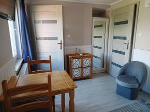 a dining room with a table and a chair at Pokoje u Stasi in Stegna