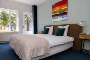 a bedroom with a bed and two windows at De Watersport Heeg in Heeg
