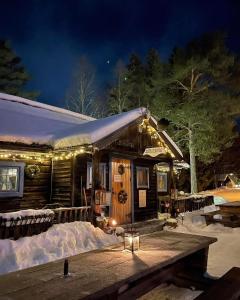 a cabin with lights in the snow at night at Lillstugan in Sälen