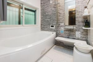 a bathroom with a tub and a toilet and a sink at Irest Village Narita in Narita +41 photos