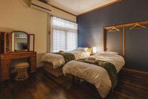 a bedroom with two beds and a mirror and a tv at Irest Village Narita in Narita