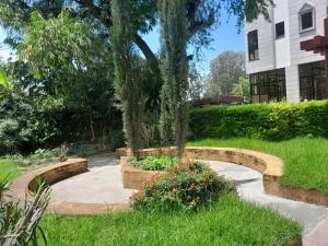 a garden with two benches and some plants at MK Hotel Hawassa in Āwasa