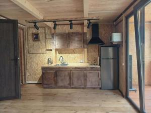 a kitchen with wooden cabinets and a refrigerator at Tsiskari in Tsaldashi