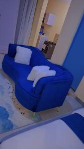 a blue couch with white pillows on it in a room at BREE'S EXECUTIVE STAYs in Kakamega